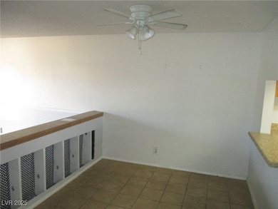 Empty room with a ceiling fan, baseboards, and til