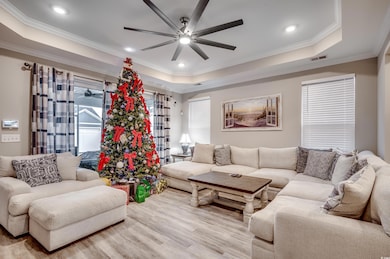 Living room with ceiling fan, light wood-type floo