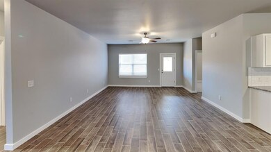 Unfurnished living room featuring wood finish floors and a ceiling fan