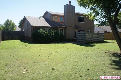 Large backyard features shade tree.