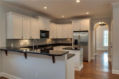 Butler pantry, between kitchen dining room, accommodates the cook with extra work space and storage Directly across is a tiled laundry, oh, so handy! Plus, a discrete powder room in the hallway.