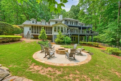 Rear view of house with an outdoor fire pit, stairs, a sunroom, a patio area, and a wooden deck