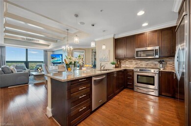 Living room with a tray ceiling, crown molding, dark hardwood / wood-style flooring, and rail lighting