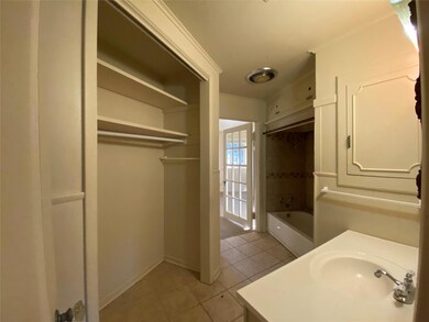 Bathroom with tile patterned flooring, vanity, crown molding, and bathing tub / shower combination