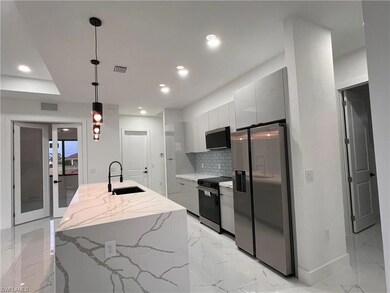 Kitchen with sink, hanging light fixtures, backspl