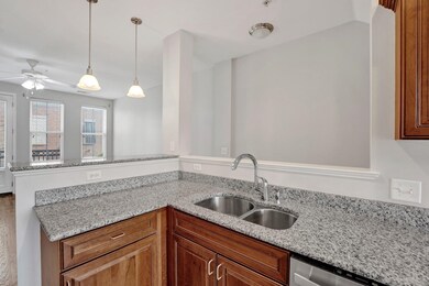 Kitchen with a ceiling fan, a sink, dishwasher, decorative light fixtures, and a peninsula