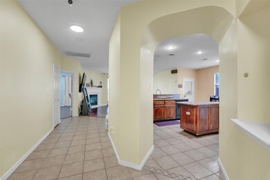 Hallway featuring sink and light tile floors