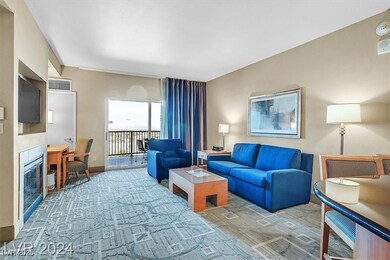Carpeted living area with a tiled fireplace, visib