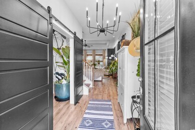 Foyer entrance with a barn door, a notable chandel