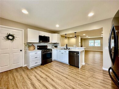 Kitchen with stainless appliances, white cabinets,