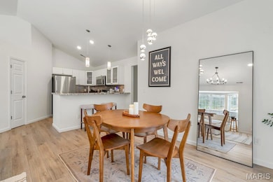 Dining space featuring light wood finished floors, lofted ceiling, recessed lighting, and a chandelier