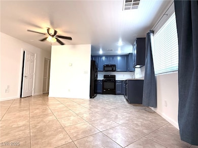 Kitchen featuring black appliances, ceiling fan, l