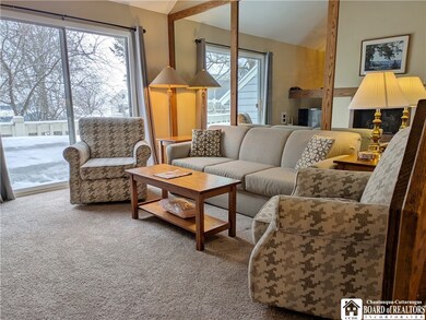 Living room opens to a porch facing the pool