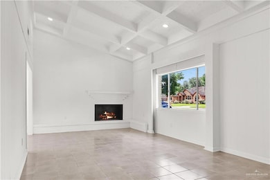 Unfurnished living room with coffered ceiling, beamed ceiling, a fireplace, light tile patterned floors, and recessed lighting