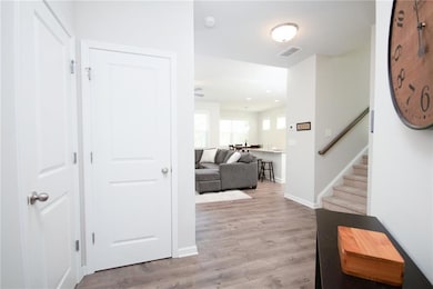 Hallway with stairway, visible vents, light wood-t