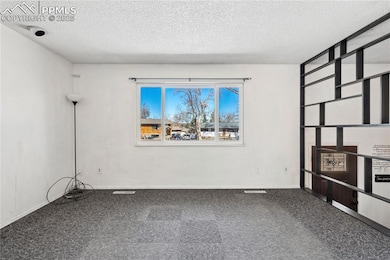 Spare room featuring carpet floors, baseboards, an