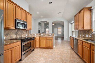  The kitchen features stainless steel appliances, granite countertops and ample storage space.