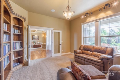 Living area with carpet, french doors, and rail lighting