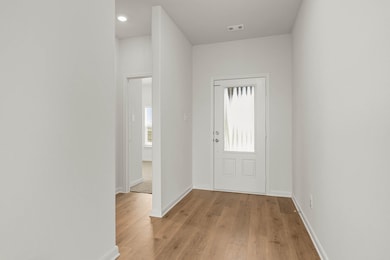 Entryway with baseboards and light wood-style floors