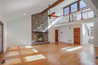 Unfurnished living room with light hardwood / wood-style flooring, beam ceiling, a fireplace, and high vaulted ceiling