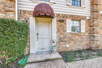 Entrance to property featuring brick siding