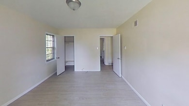 Unfurnished room with light wood finished floors and baseboards