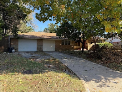 Single story home with brick siding, driveway, and an attached garage