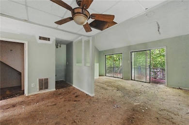 Empty room featuring a ceiling fan and lofted ceiling