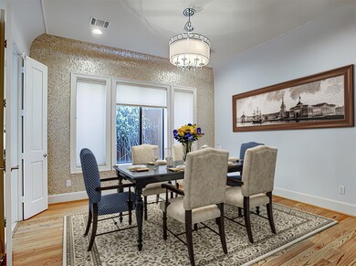 DINING ROOM - (14 x 14)  The focal point of the dining room is the mother-of-pearl mosaic tile accent wall and exquisite chandelier.  (Photo is virtually staged.)