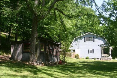 A side view from the historic old shed on the property toward the side of the house.  The shed is perfect for storage of lawn equipment, could be made into an art studio.