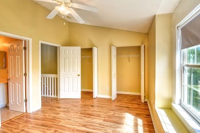 Unfurnished bedroom featuring lofted ceiling, a te
