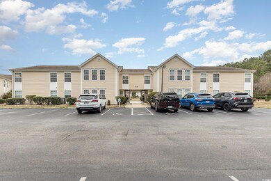 View of building exterior with uncovered parking