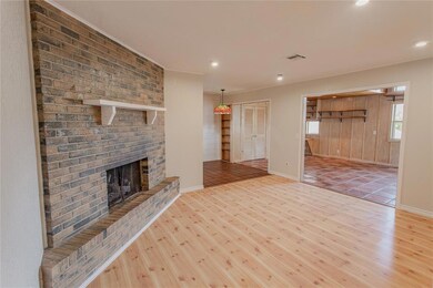 Unfurnished living room with brick wall, light har
