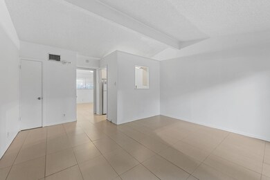 Unfurnished room with a textured ceiling, tile pa