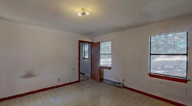 Spare room featuring light floors and baseboards