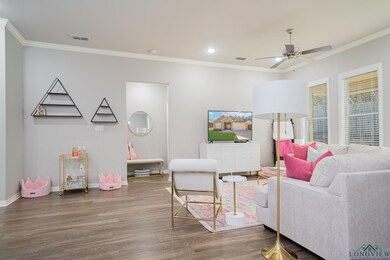 Living room featuring wood finished floors, crown molding, a ceiling fan, and recessed lighting