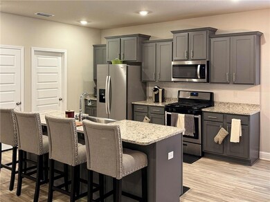 Kitchen featuring stainless steel appliances, backsplash, light wood-style floors, a breakfast bar, and recessed lighting