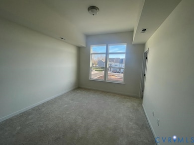 Carpeted spare room featuring baseboards