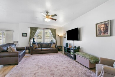 Living area with wood finished floors and a ceiling fan