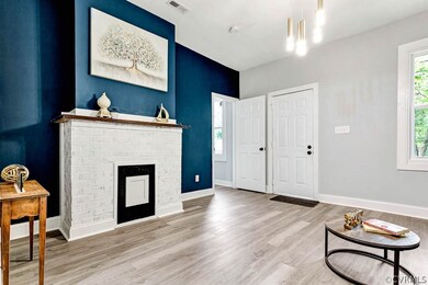 Living room with a fireplace and wood-type flooring