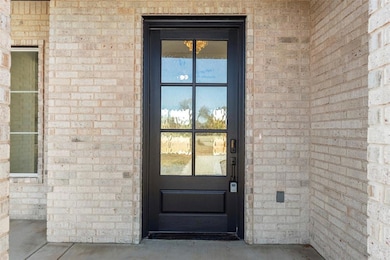 View of exterior entry featuring brick siding