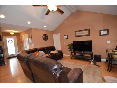 Living room with laminate wood flooring, vaulted c