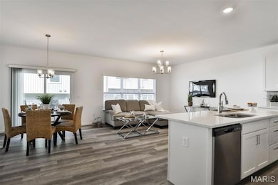 Kitchen with a chandelier, white cabinets, open floor plan, dishwasher, and dark wood-style flooring