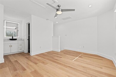 Spare room with a ceiling fan, a sink, light wood