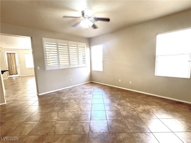 Unfurnished room with a ceiling fan and tile patte