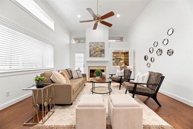 Light and bright den with wood burning or gaslog fireplace, high ceilings, wet bar with beverage fridge and door to patio.