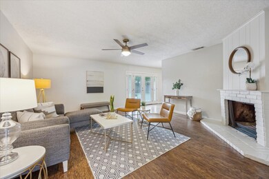 Living room with ceiling fan, wood finished floor