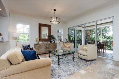 Living area featuring ornamental molding, stone tile floors, and healthy amount of natural light