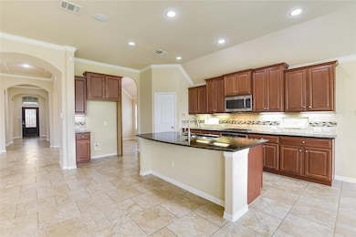Kitchen with arched walkways, backsplash, dark st
