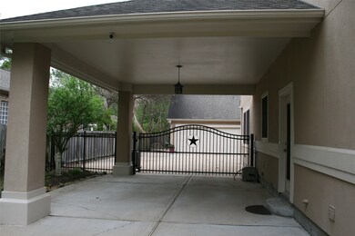 Lighted porte cochere with electric gate (and garage opener).  Door to the right is the side entrance into home.